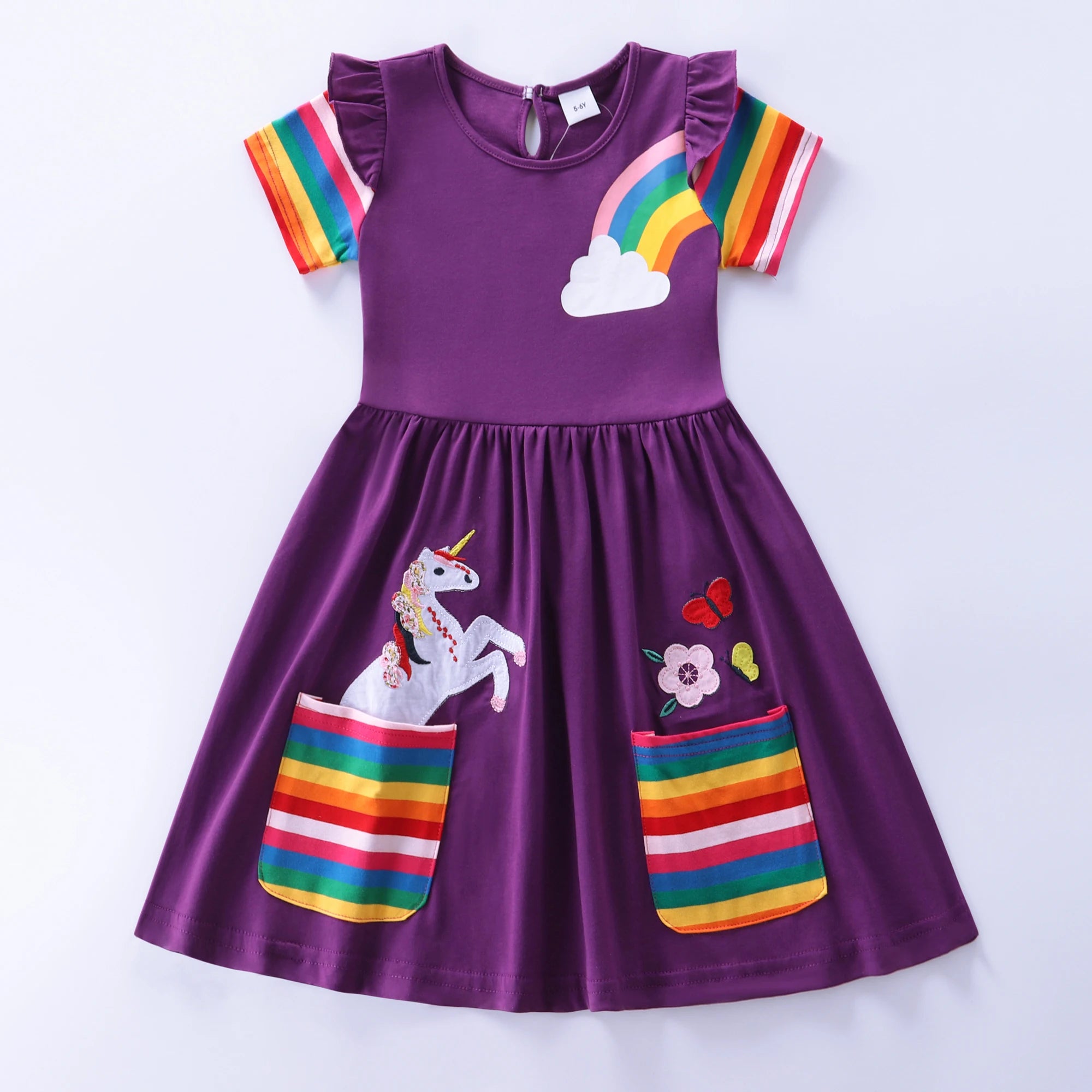 Purple dress with rainbow and unicorn designs on a white background