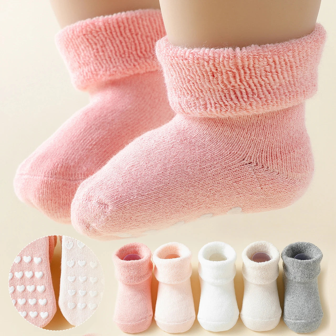 Pink baby socks with textured sole and additional pairs displayed below on a light background.