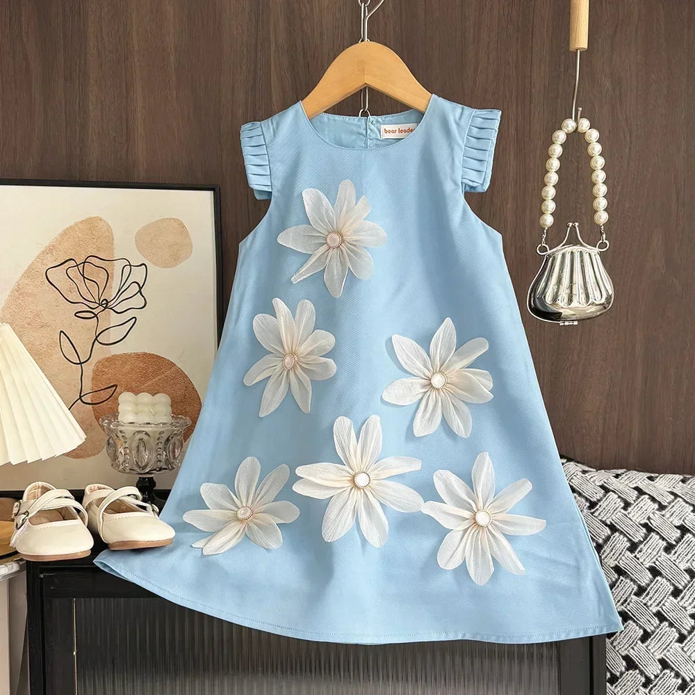 Light blue dress with white floral patterns on a wooden hanger against a wooden wall.