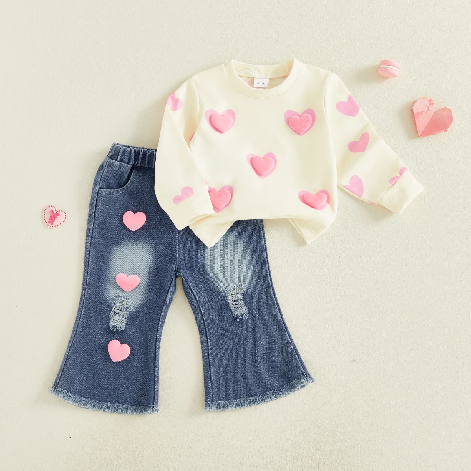 Children's outfit with heart-patterned shirt and jeans on a light background