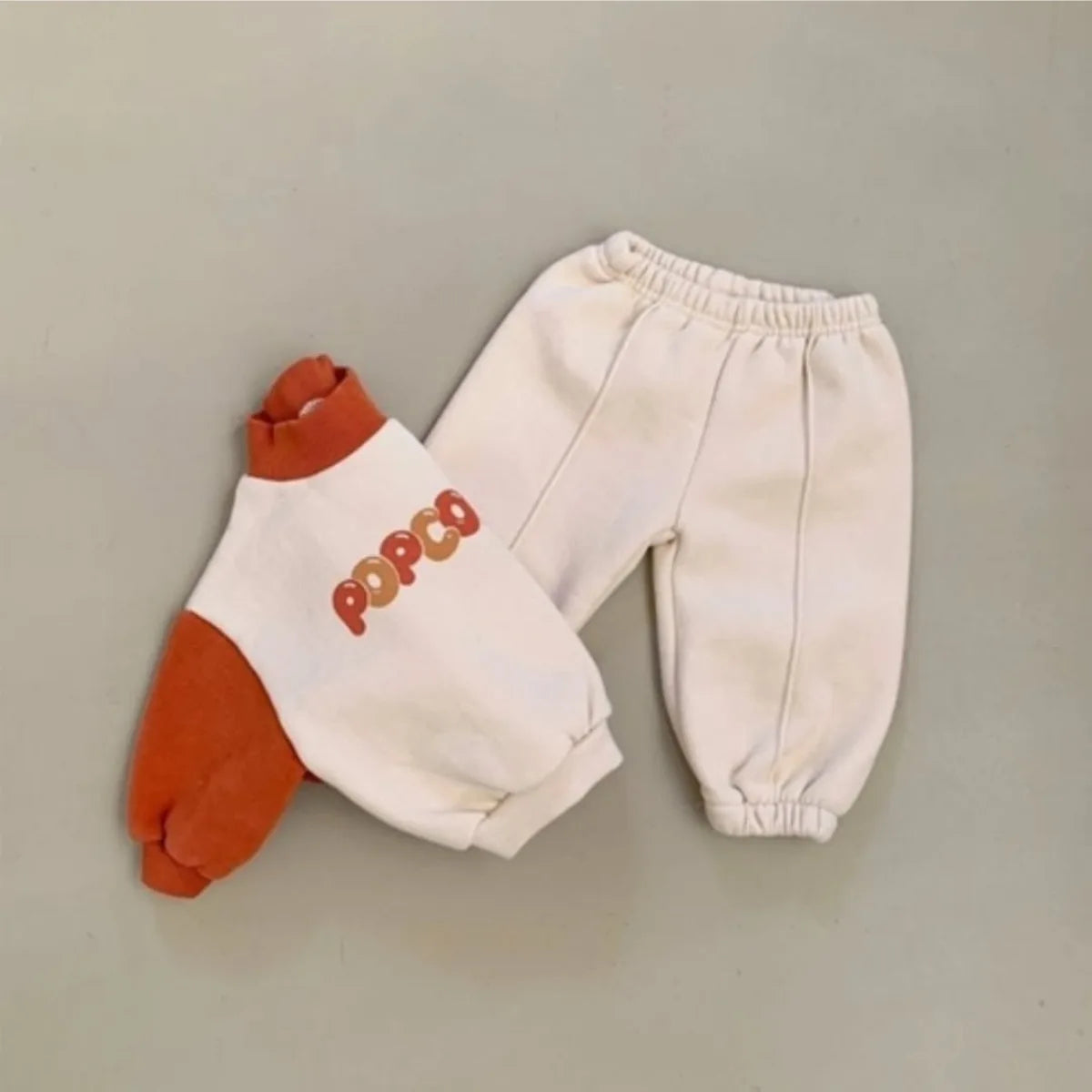 Children's outfit with a sweatshirt and pants on a plain background