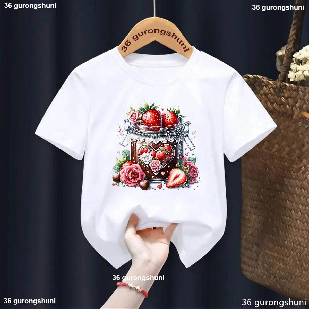 White t-shirt with strawberry design on a hanger against a dark background