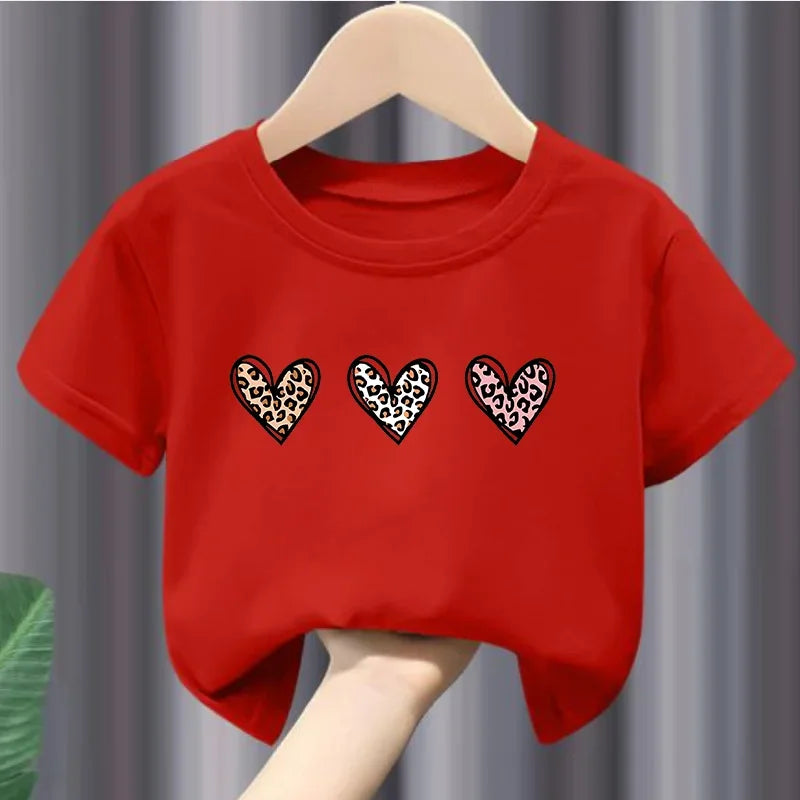 Red t-shirt with leopard print hearts on a hanger against a gray curtain background