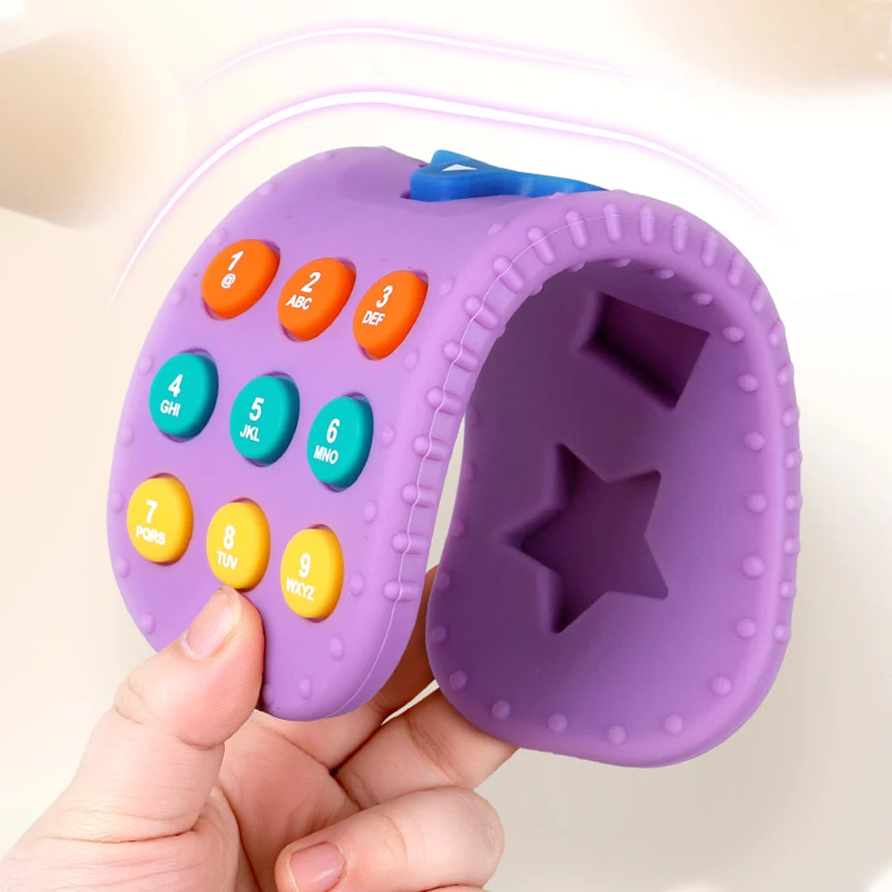 Purple toy with number buttons and star shape held by a hand against a light background
