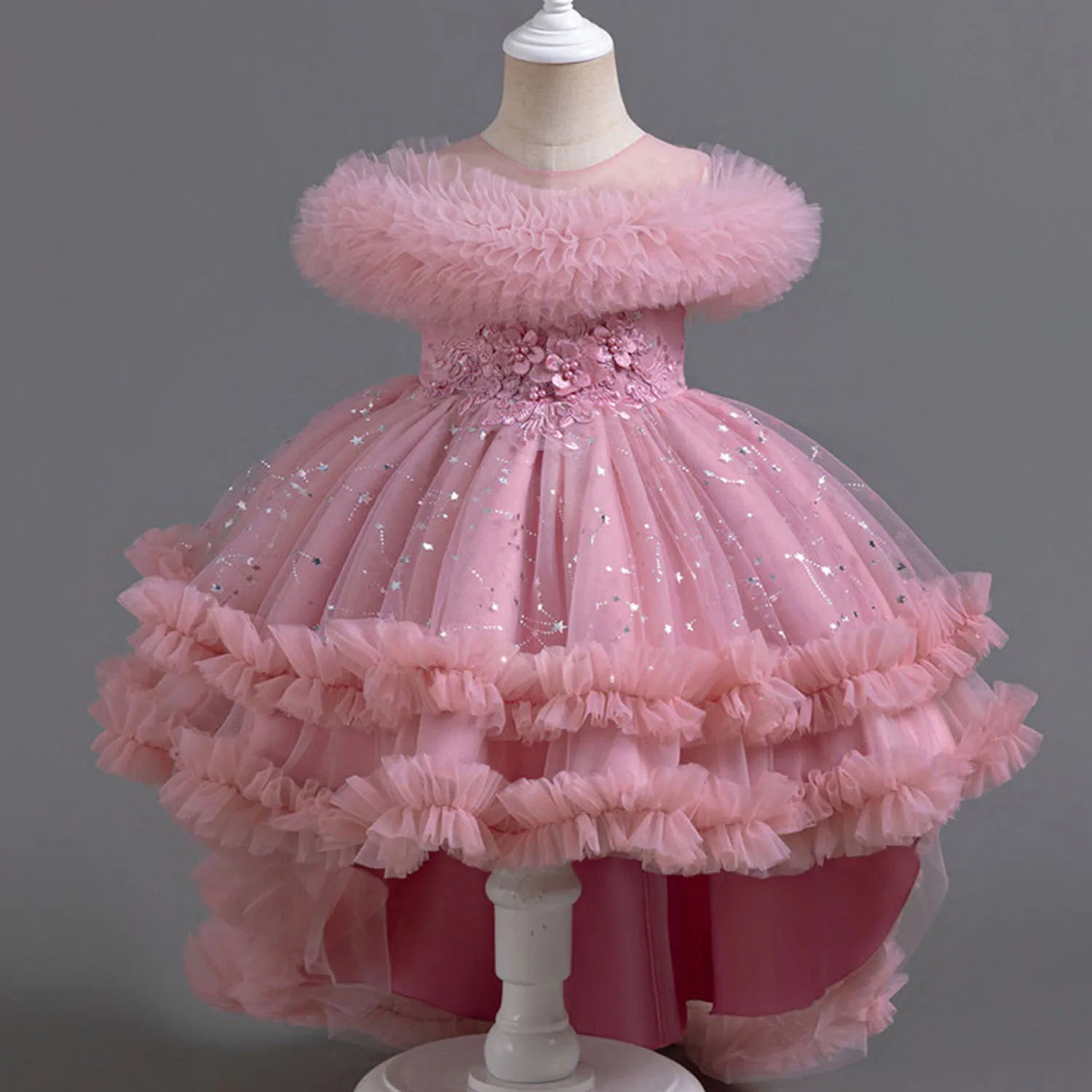 Pink children's dress on a mannequin against a gray background