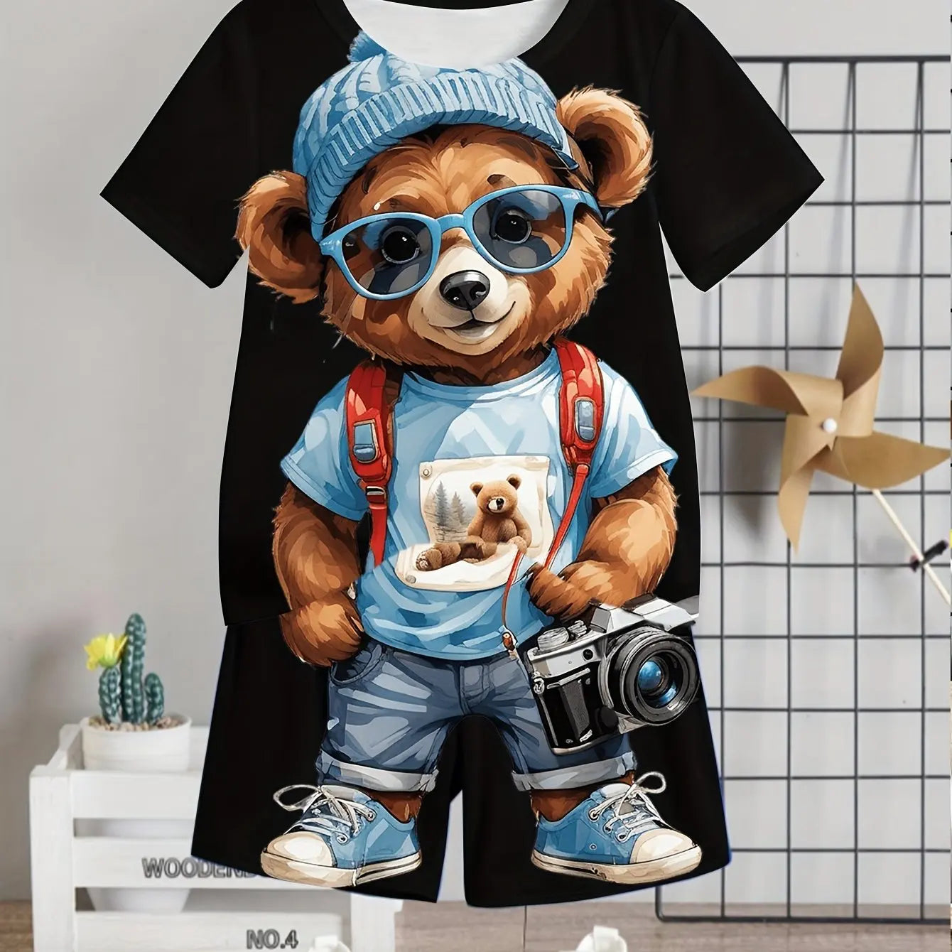 T-shirt with a bear design wearing sunglasses, a cap, and overalls with a camera and teddy bear image.