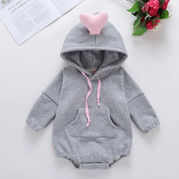 Gray baby romper with pink heart on hood and flowers in the background