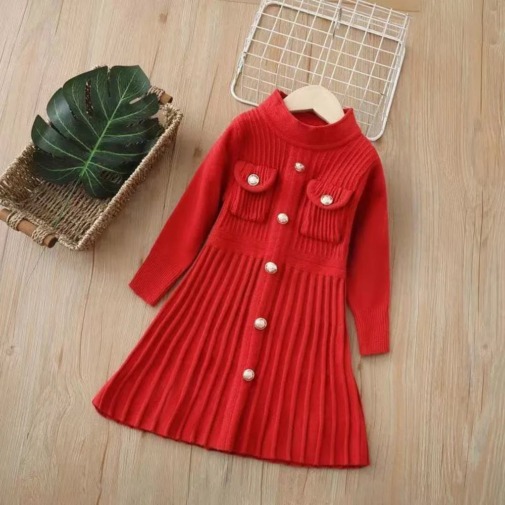 Red knitted dress with buttons on a wooden surface