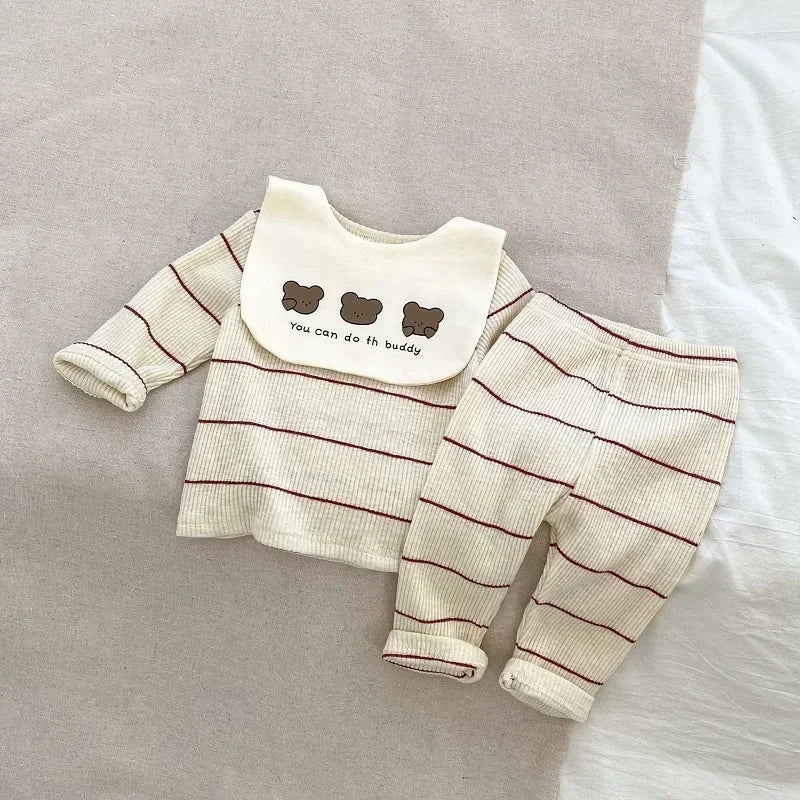 Baby outfit with striped shirt, bib, and pants on a neutral background