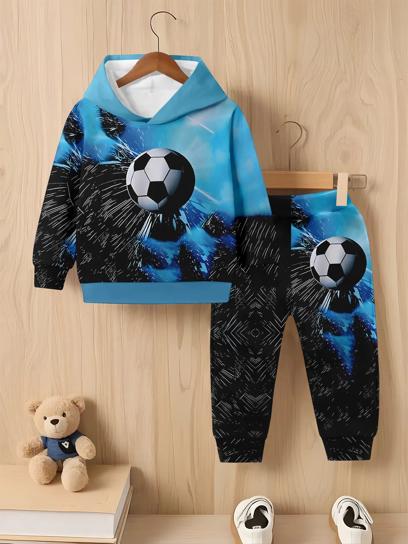 Children's hoodie and pants set with soccer ball design on a wooden background